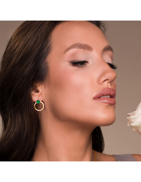 Gros plan des boucles d’oreilles STARDUST avec cristaux verts portées par le mannequin